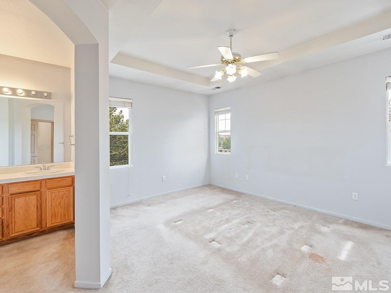 1287 Tule Drive Reno, NV 89521 - Photo 18 of 32 an empty room with chandelier fan and windows