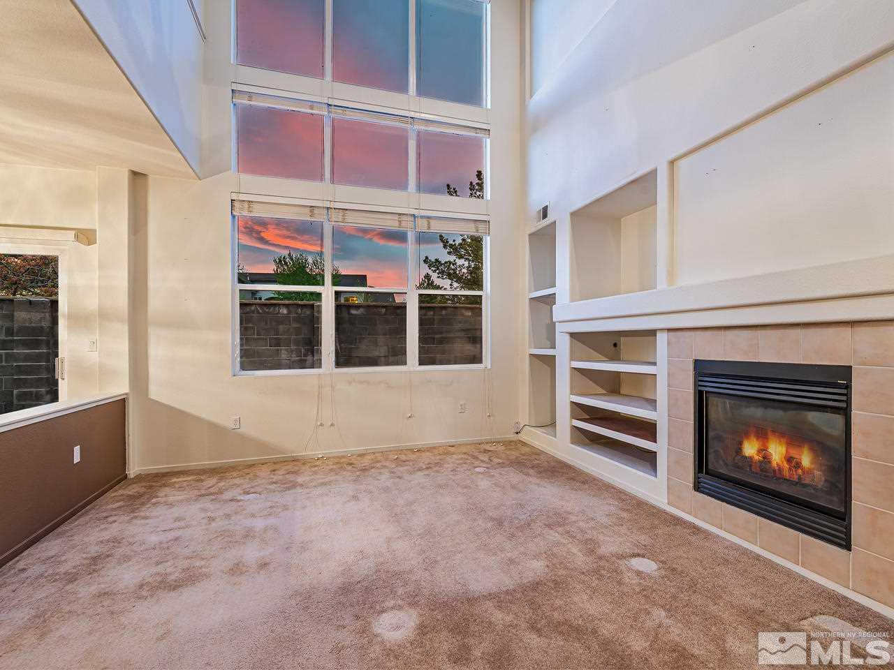1287 Tule Drive Reno, NV 89521 - Photo 5 of 32 a view of an empty room with a fireplace and a window