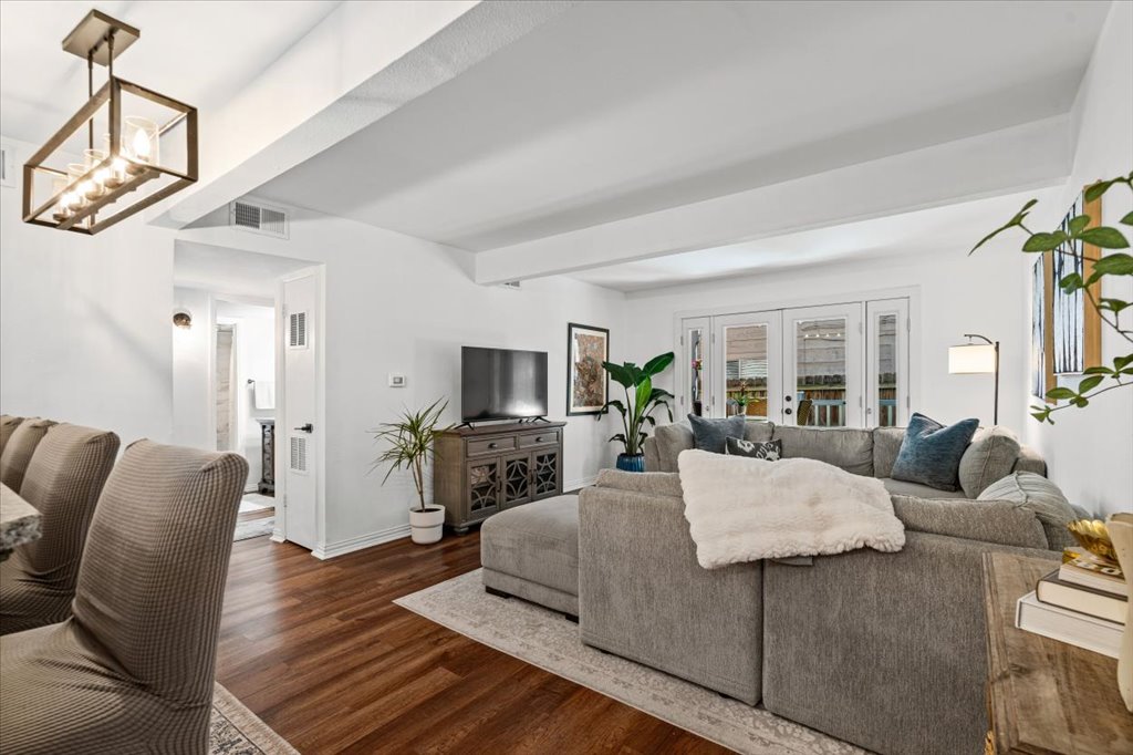 a living room with furniture a flat screen tv and a dining table