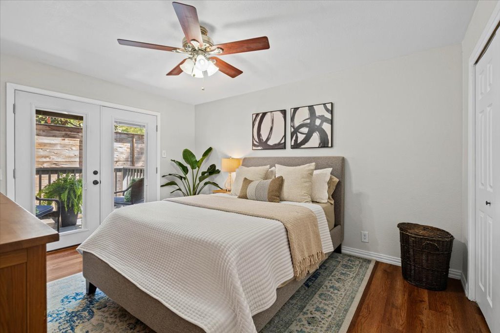 2208 Enfield Road, Unit 107 Austin, TX 78703 - Photo 18 of 35 a bedroom with a bed and wooden floor