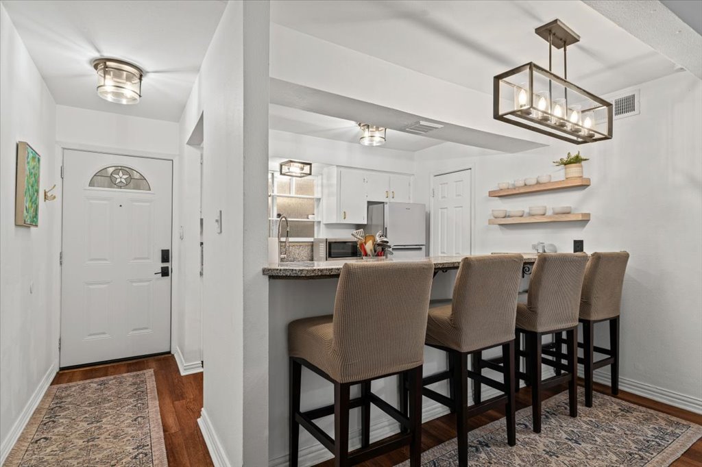 2208 Enfield Road, Unit 107 Austin, TX 78703 - Photo 4 of 35 a view of a dining room with furniture a chandelier and wooden floor