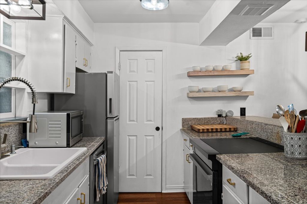 2208 Enfield Road, Unit 107 Austin, TX 78703 - Photo 6 of 35 a kitchen with stainless steel appliances granite countertop a sink stove and refrigerator