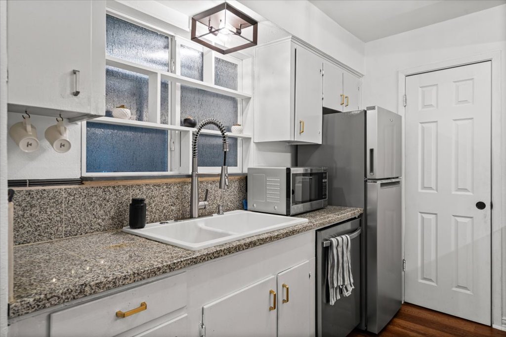 2208 Enfield Road, Unit 107 Austin, TX 78703 - Photo 7 of 35 a kitchen with stainless steel appliances granite countertop a sink stove and refrigerator