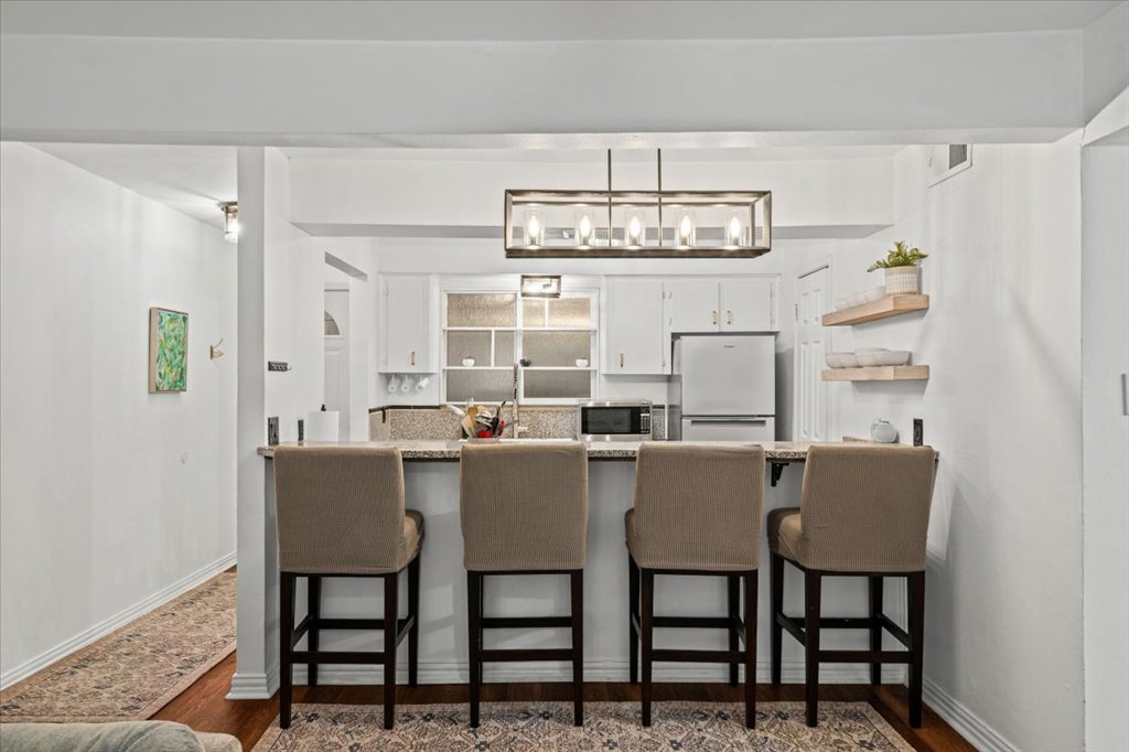 2208 Enfield Road, Unit 107 Austin, TX 78703 - Photo 9 of 35 a view of a dining room with furniture a chandelier and wooden floor