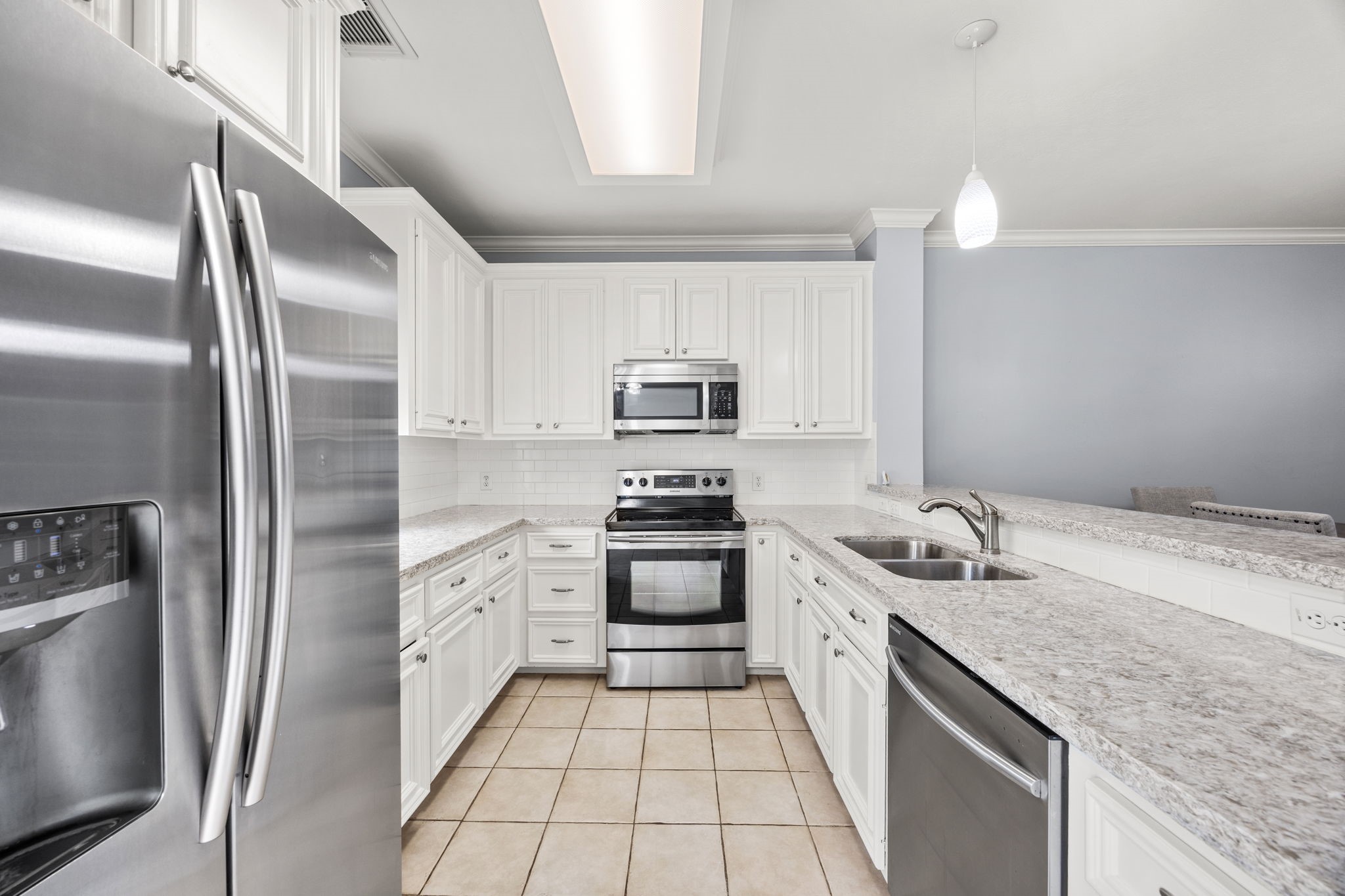 3023 Austin Street Houston, TX 77004 - Photo 13 of 26 Beautiful kitchen features stainless appliances, granite counters, white cabinets, tile floors