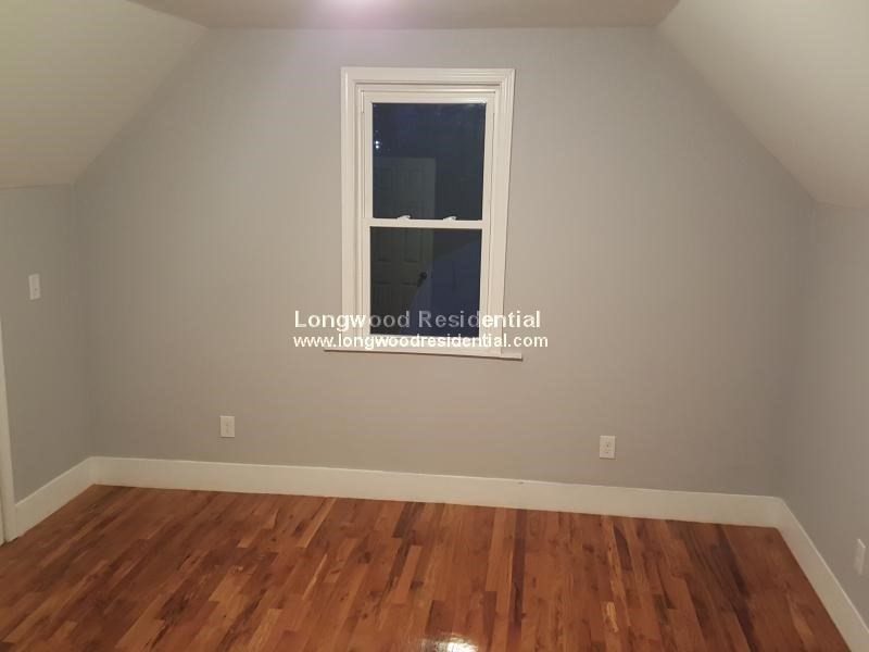 39 Pinckney Street, Unit 3 Somerville, MA 02145 - Photo 13 of 17 an empty room with wooden floor and windows