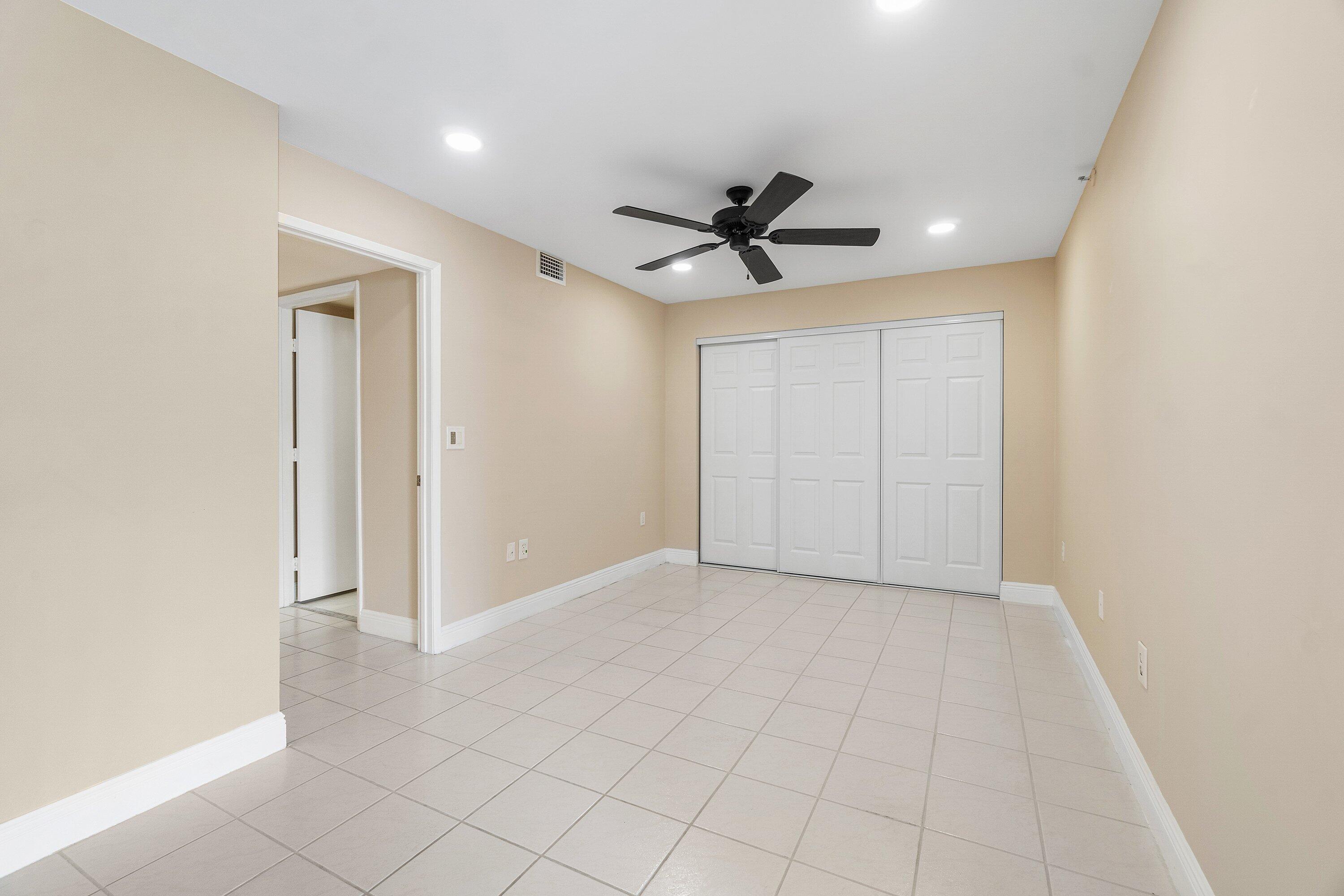 14096 Huntington Pointe Drive, Unit 106 Delray Beach, FL 33484 - Photo 27 of 47 an empty room with a ceiling fan and a window