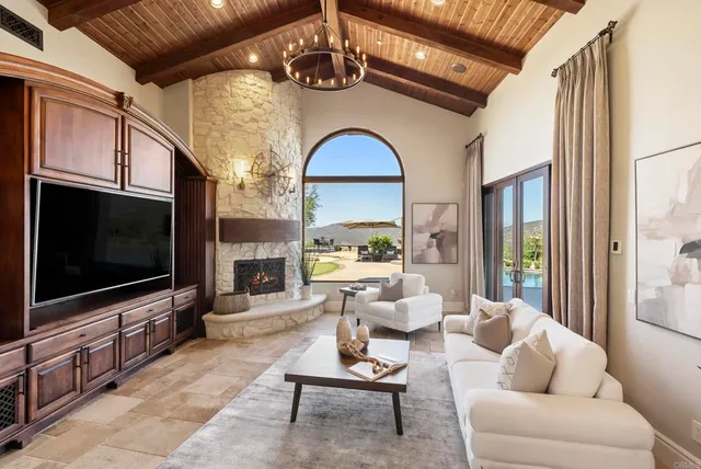 a living room with furniture a flat screen tv and a floor to ceiling window