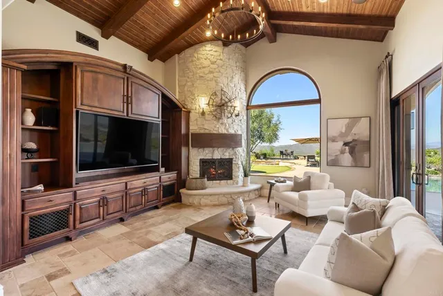 a living room with furniture a flat screen tv and a fireplace