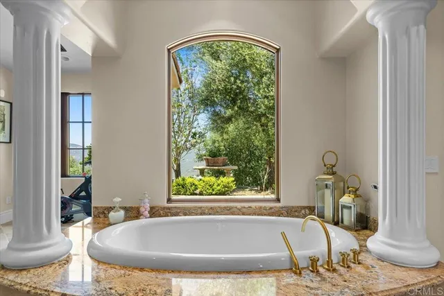 a spacious bathroom with a tub and a large window