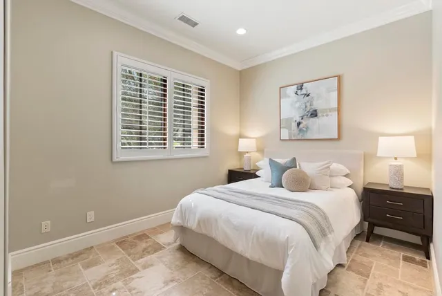 a bedroom with a large bed and a chandelier
