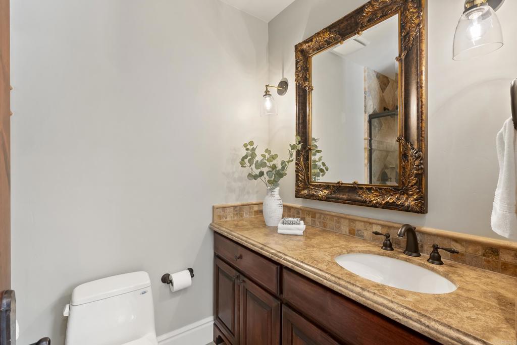 18320 Via Ambiente Rancho Santa Fe, CA 92067 - Photo 30 of 59 a bathroom with a granite countertop sink and a mirror with toilet