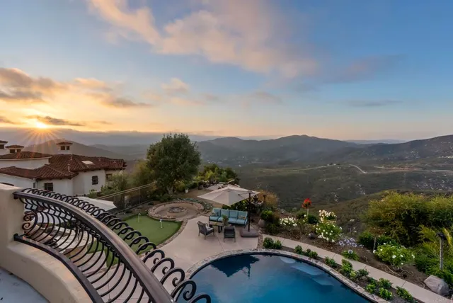 a view of a white house with a big yard and potted plants
