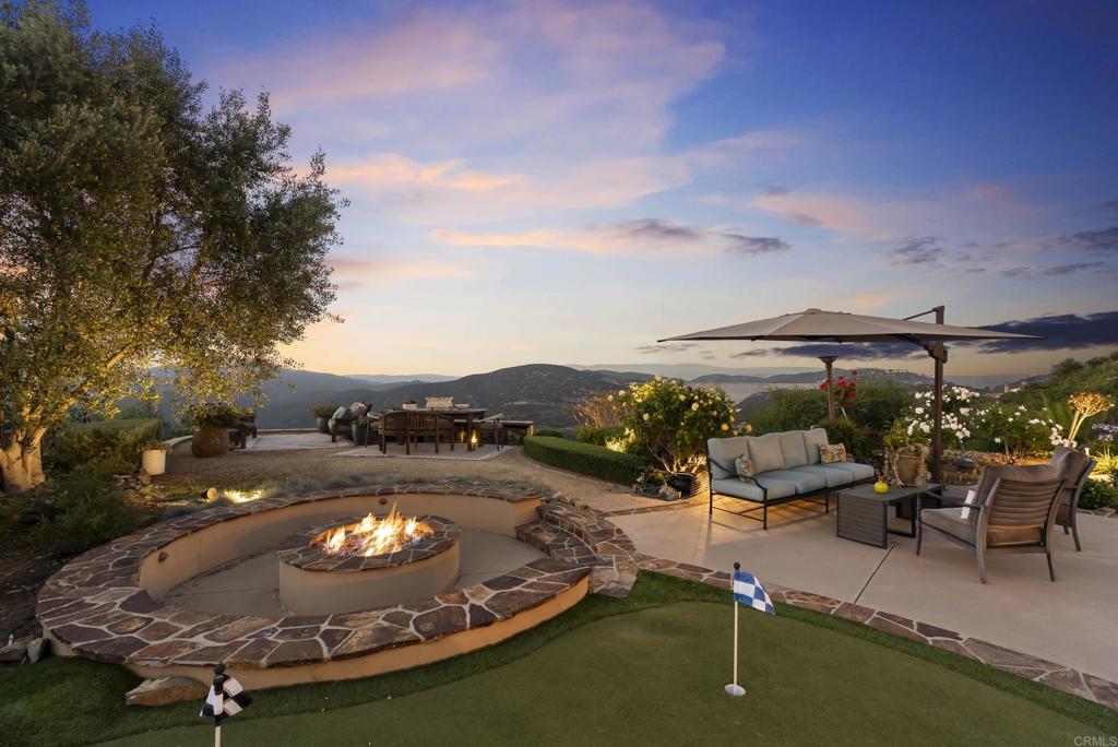 18320 Via Ambiente Rancho Santa Fe, CA 92067 - Photo 44 of 59 a view of a swimming pool with lawn chairs under an umbrella