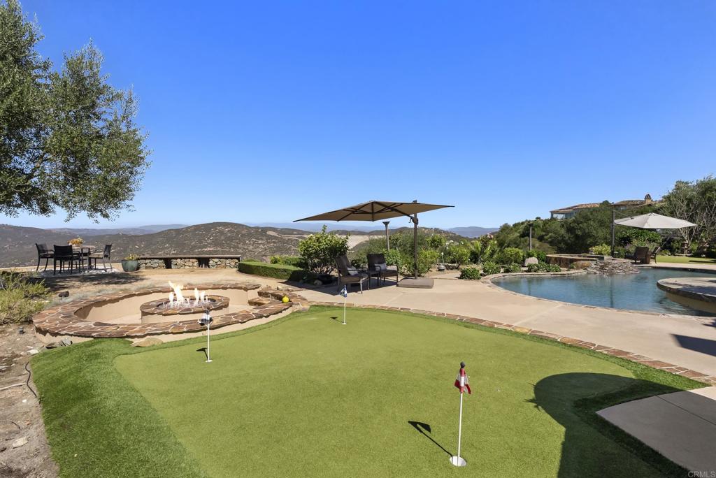 18320 Via Ambiente Rancho Santa Fe, CA 92067 - Photo 48 of 59 a view of a swimming pool with lawn chairs under an umbrella