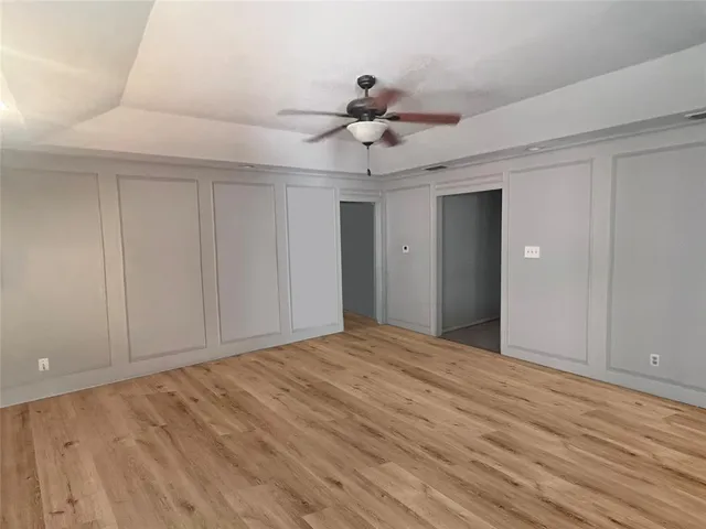 a view of an empty room and chandelier fan
