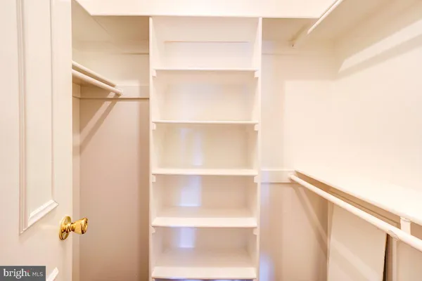 a view of walk in closet with empty racks