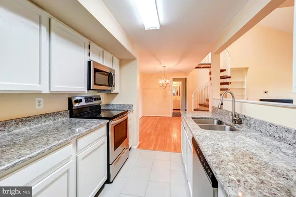 a large kitchen with granite countertop a sink and cabinets