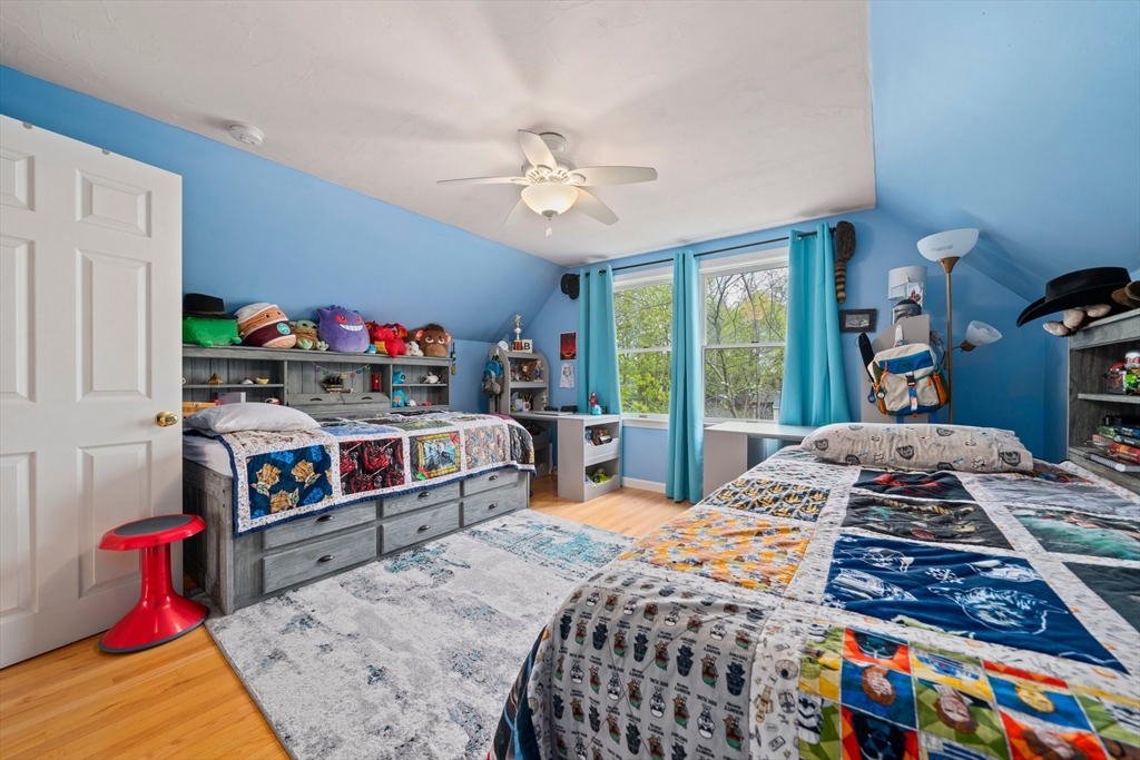 80 King Street Hanover, MA 02339 - Photo 19 of 34 a bedroom with a bed a dresser and a chandelier