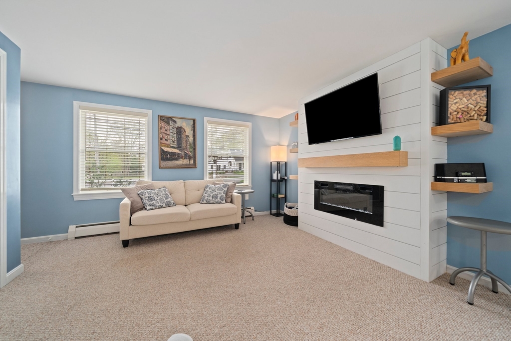 80 King Street Hanover, MA 02339 - Photo 9 of 34 a living room with furniture a flat screen tv and a fireplace