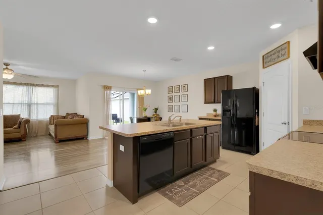 a kitchen with stainless steel appliances granite countertop a sink and a refrigerator