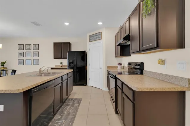 a kitchen with stainless steel appliances granite countertop a sink stove refrigerator and a granite counter top