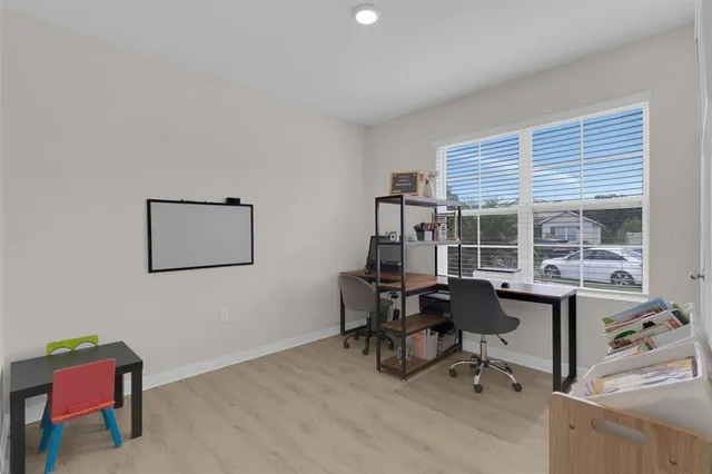 a view of a workspace with furniture and a window