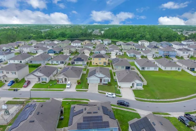 an aerial view of residential houses with outdoor space and parking