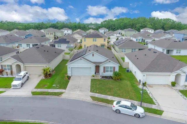 an aerial view of a house with garden space and street view
