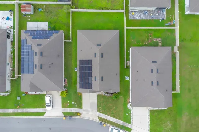 an aerial view of a house with a backyard space