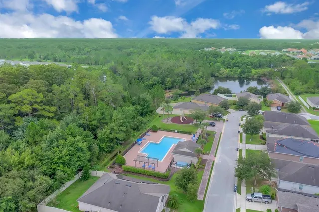 an aerial view of residential houses with outdoor space and trees