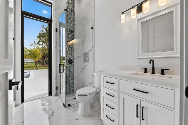 a bathroom with a granite countertop sink toilet and shower