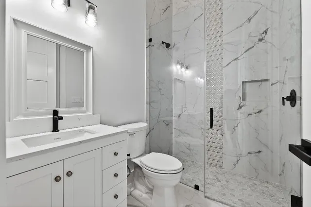 a bathroom with a sink a toilet and shower