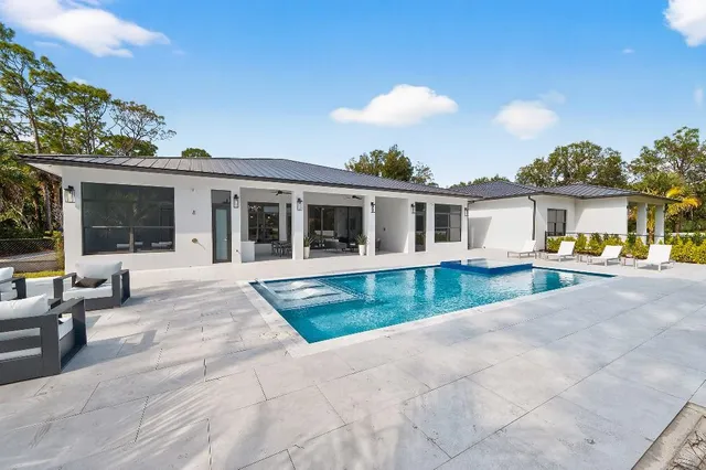 a view of house with swimming pool and sitting area