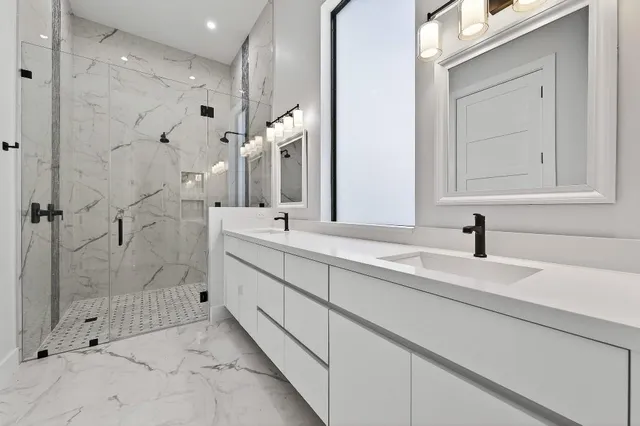 a bathroom with a double vanity sink mirror and shower