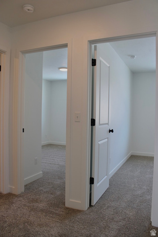 2613 Scarlet Road, Unit 258 Eagle Mountain, UT 84005 - Photo 24 of 32 Hallway with light gray carpeting, white trim, and white paneled doors with black hardware