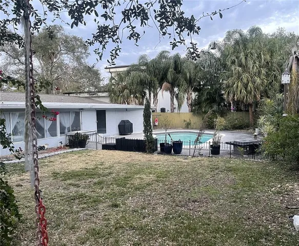 a view of a house with backyard and sitting area