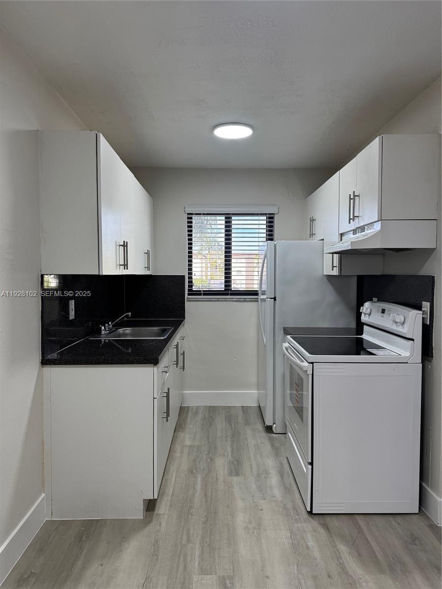 1330 West 29th Street, Unit 33 Hialeah, FL 33012 - Photo 16 of 18 a kitchen with a sink a stove and cabinets
