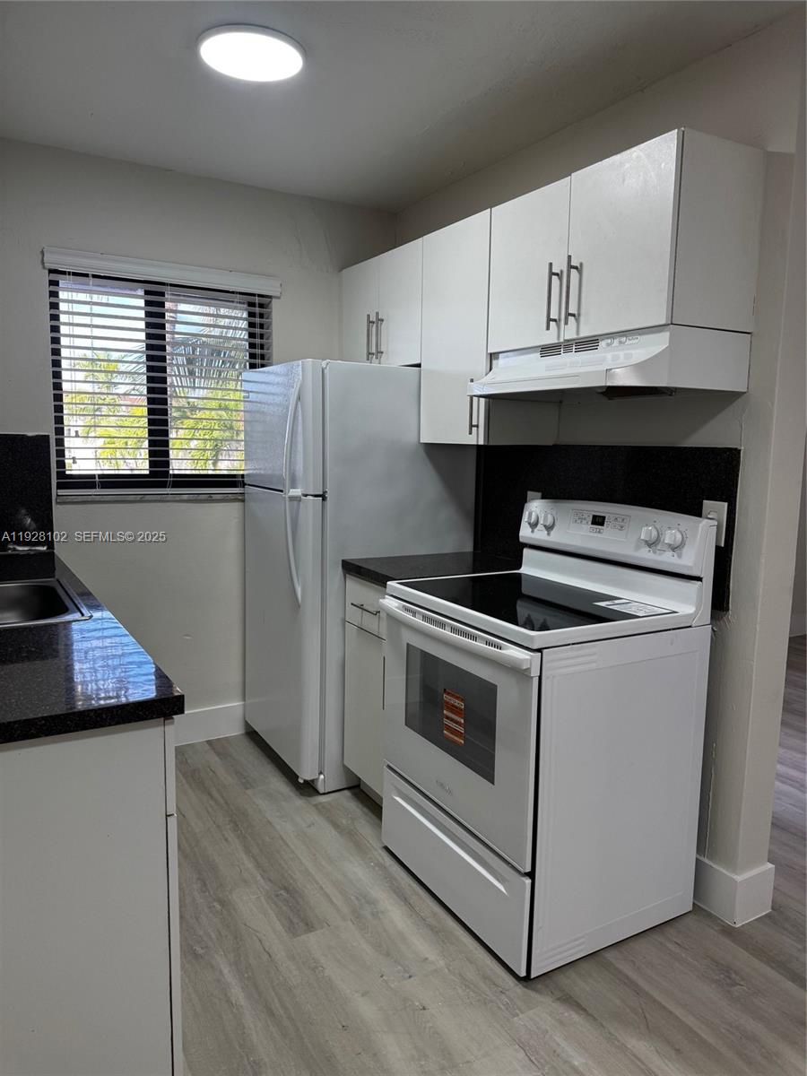 1330 West 29th Street, Unit 33 Hialeah, FL 33012 - Photo 17 of 18 a kitchen with a stove a refrigerator and cabinets