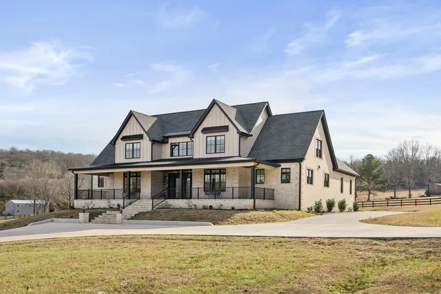 a front view of a house with a garden and lake view