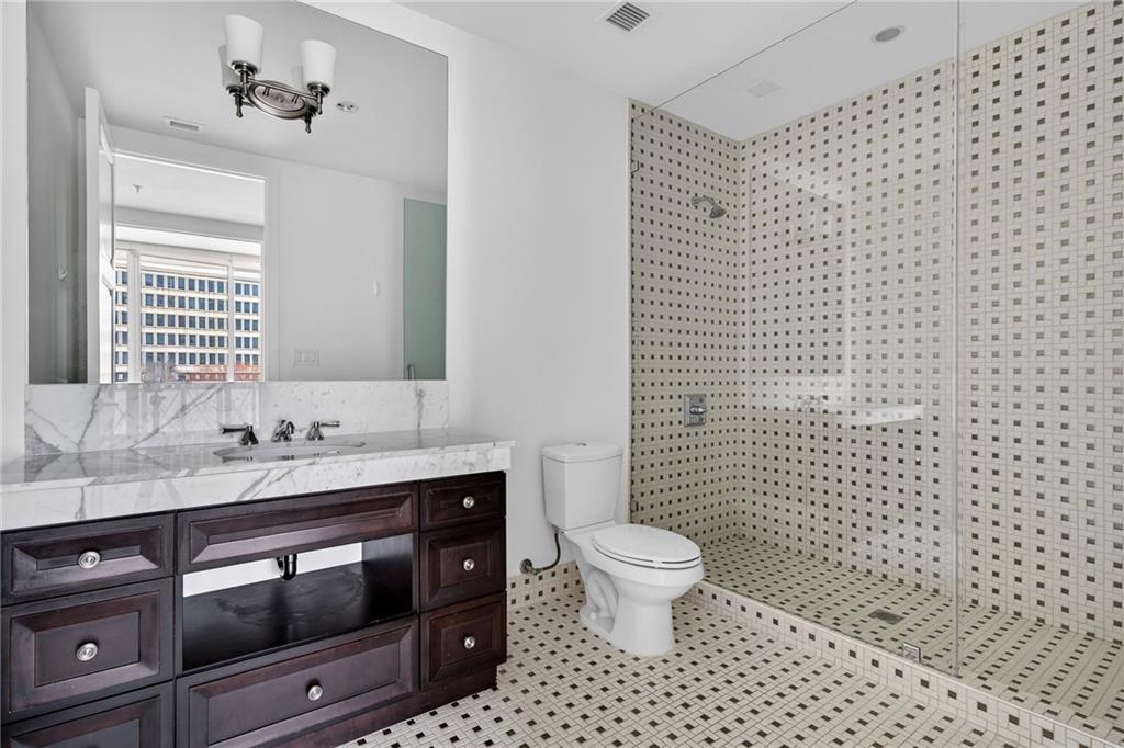 1820 Peachtree Road Northwest, Unit 312 Atlanta, GA 30309 - Photo 29 of 51 a bathroom with a sink toilet a mirror and shower