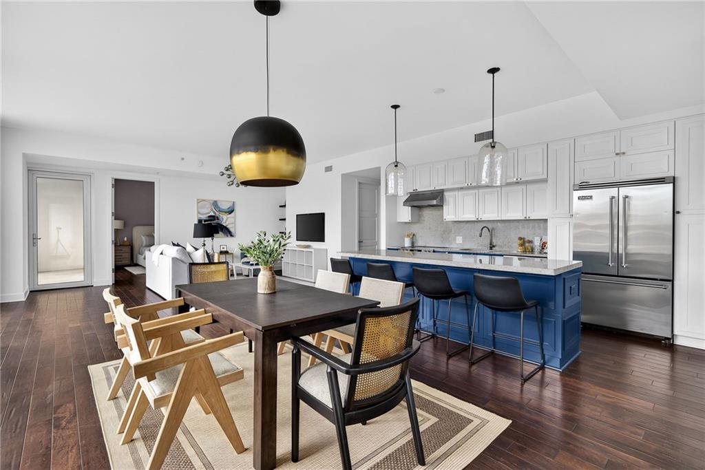 1820 Peachtree Road Northwest, Unit 312 Atlanta, GA 30309 - Photo 8 of 51 a kitchen with stainless steel appliances granite countertop a stove a refrigerator a sink dishwasher a dining table and chairs with wooden floor