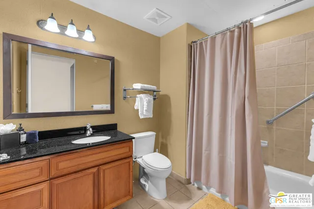 a bathroom with a double vanity sink toilet and a mirror