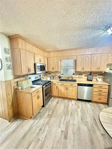 a kitchen with stainless steel appliances a stove top oven and a refrigerator