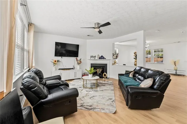 a living room with furniture kitchen view and a large window