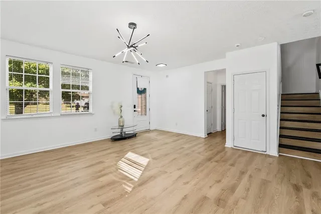 a view of empty room with wooden floor and window