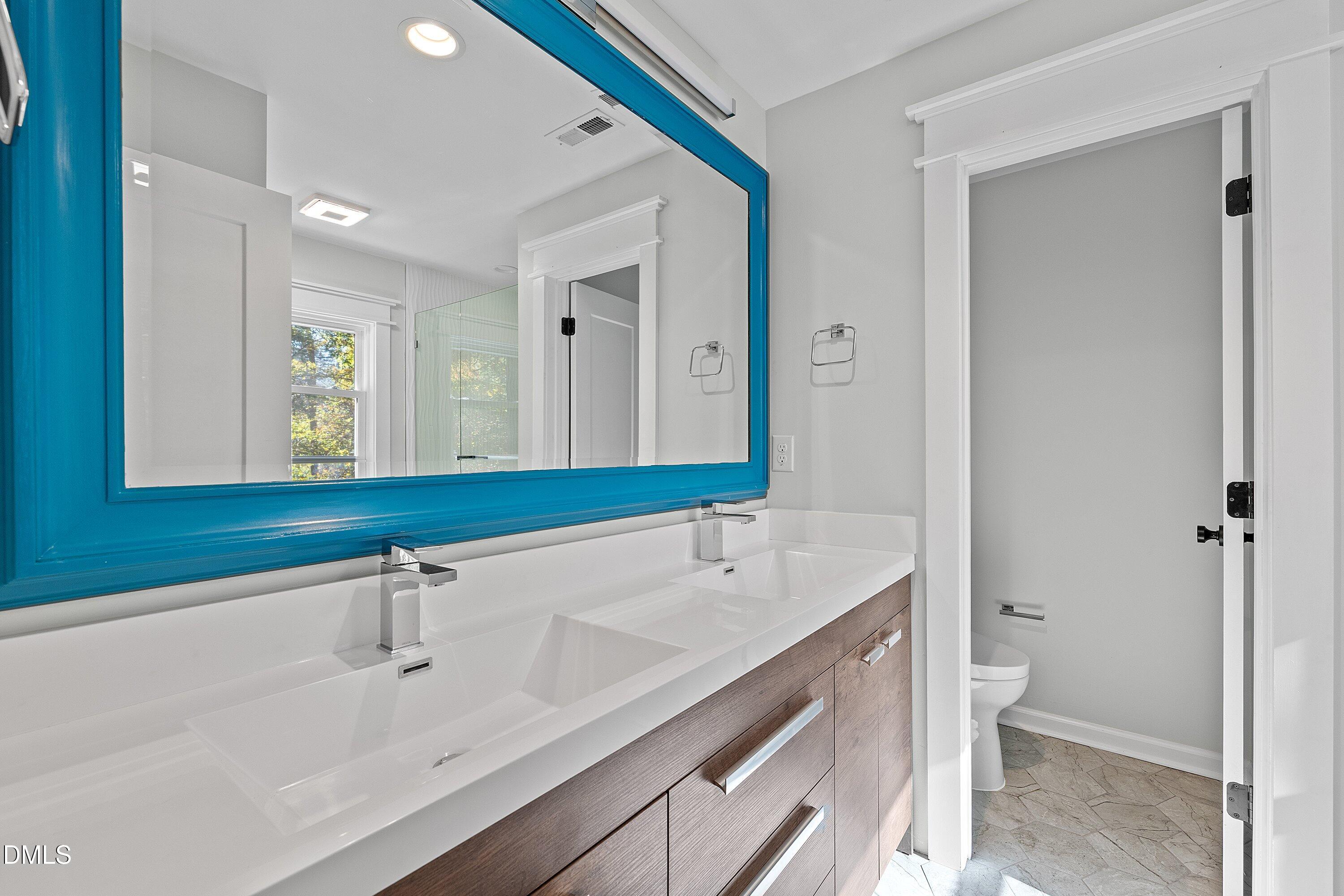 1124 Hardimont Road Raleigh, NC 27609 - Photo 14 of 34 a bathroom with a sink and a mirror