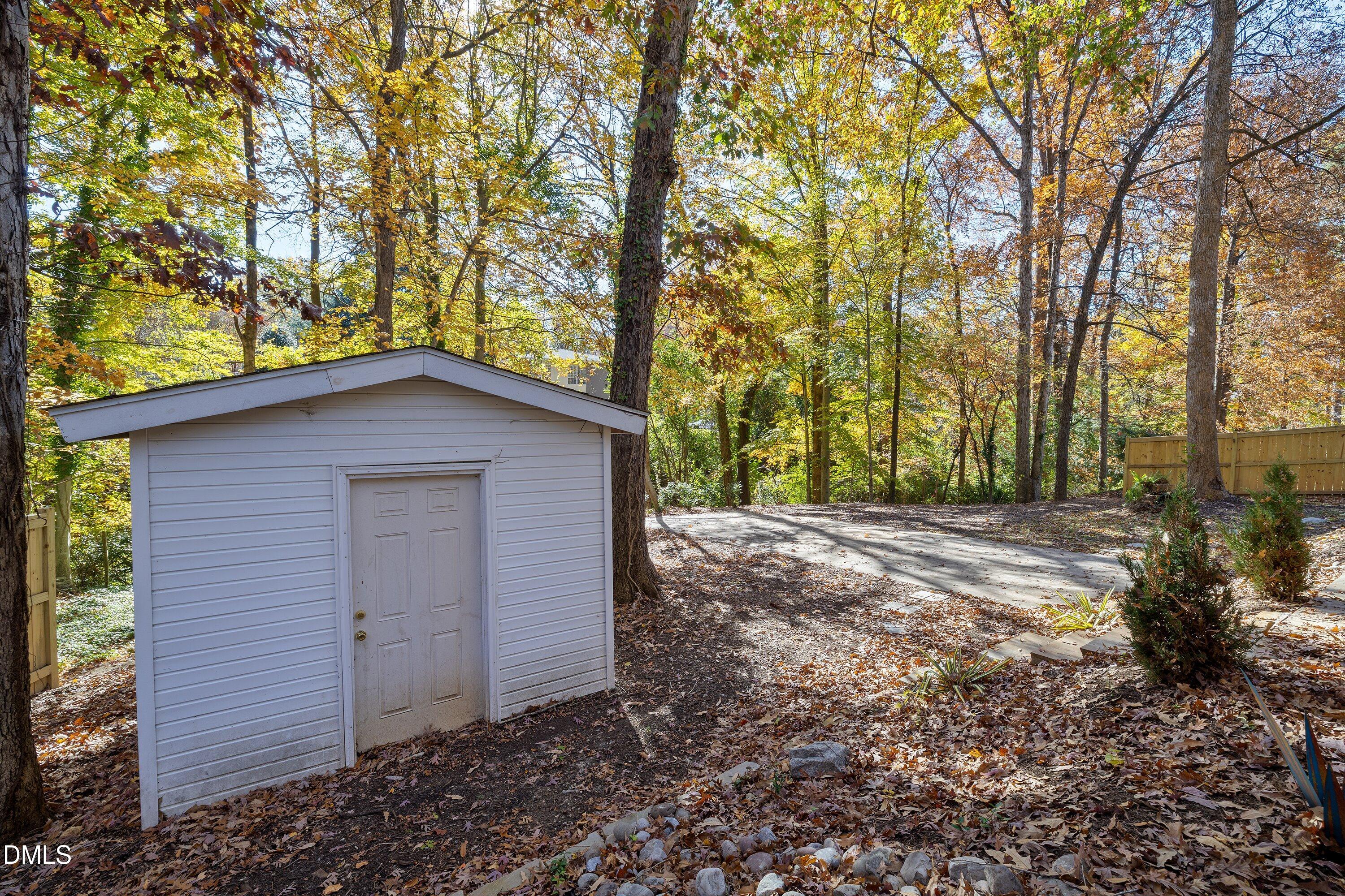 1124 Hardimont Road Raleigh, NC 27609 - Photo 30 of 34 a backyard of a house with large trees and a barn