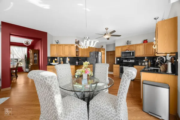 a dining room with furniture a chandelier and kitchen view