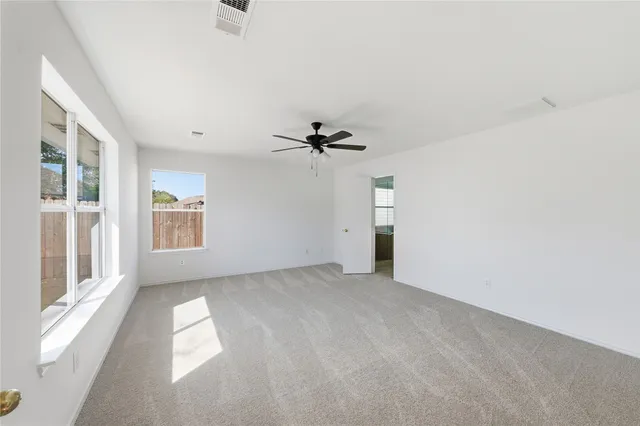 a view of a livingroom with a ceiling fan and window